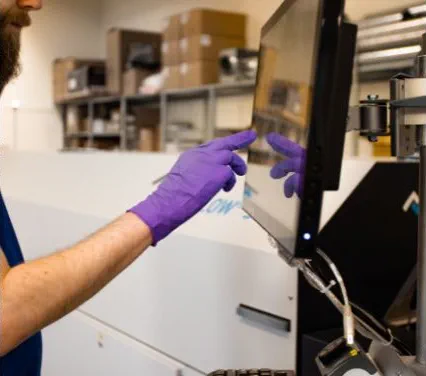Operator in ESD gloves at the touchscreen of a reflow soldering oven